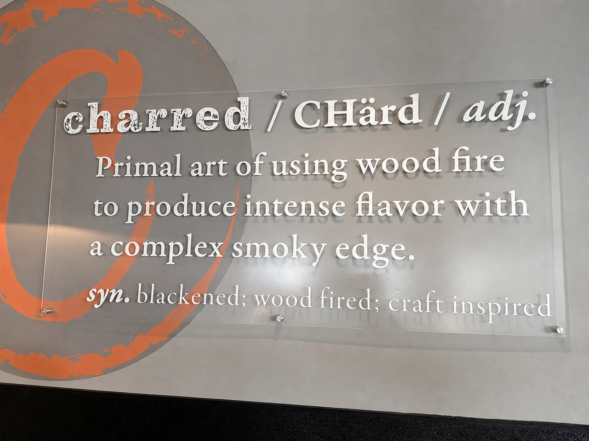 The charred definition sign mounted on the dining room wall
