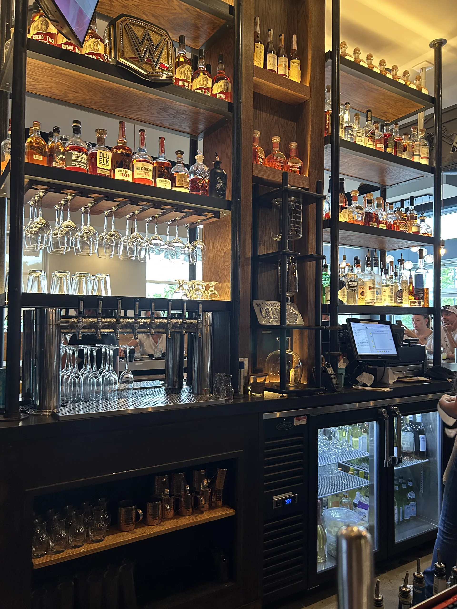 Whiskey bottles and glassware arranged across Charred's back bar