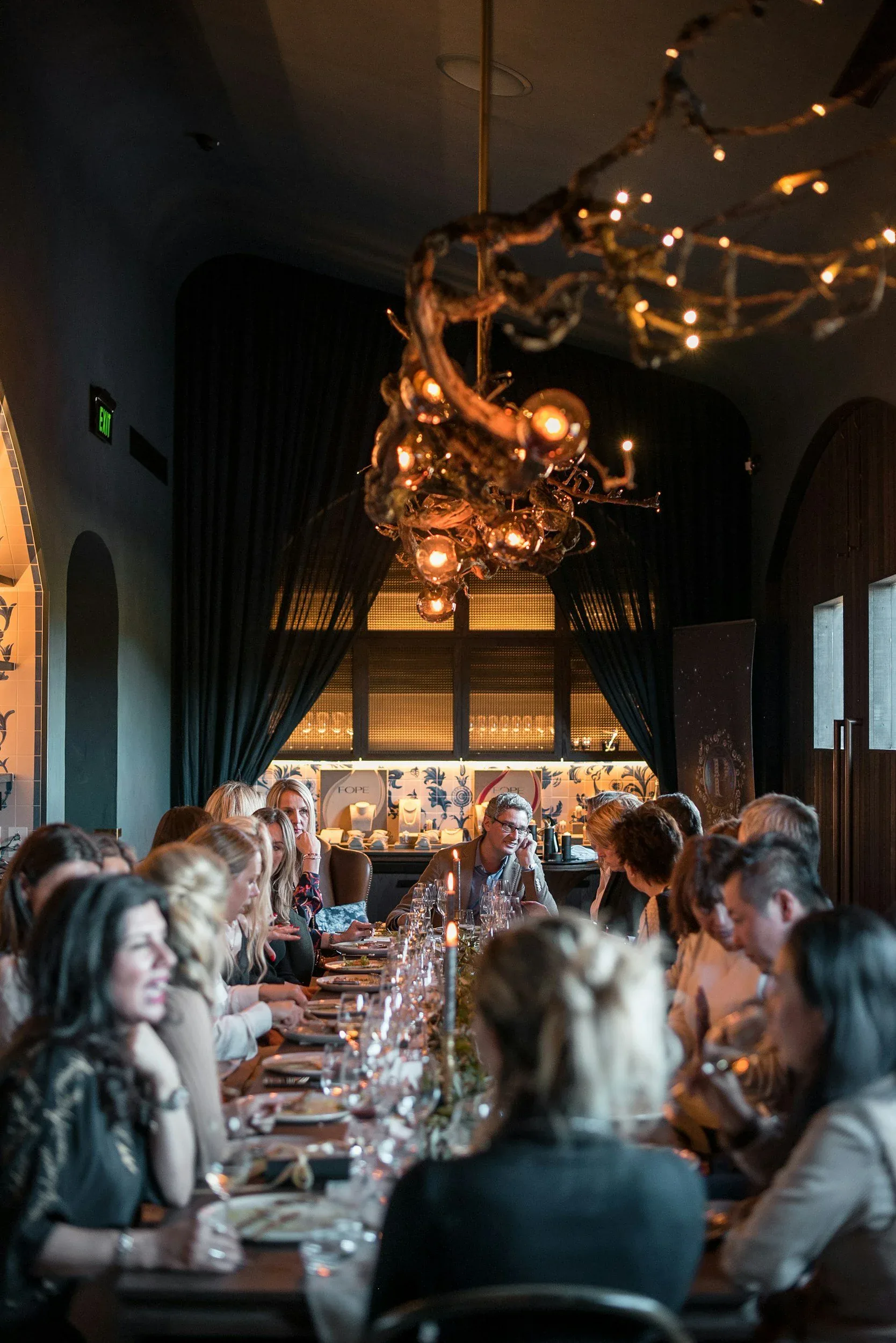 Guests gathered around a candlelit long table in Charred's private dining room