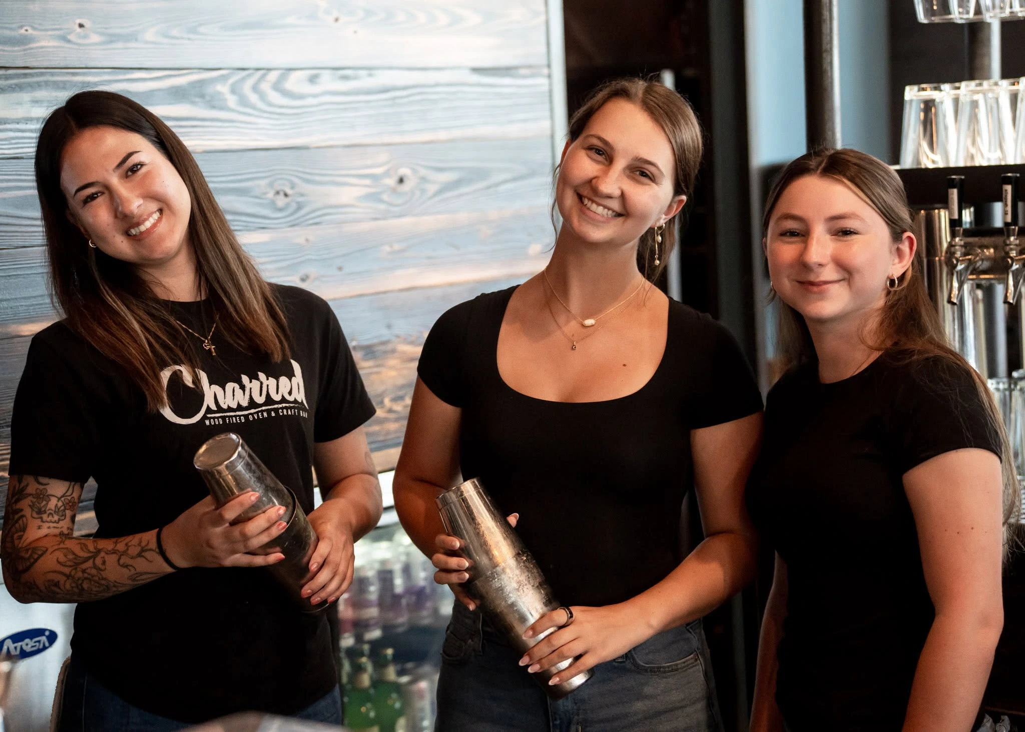 Three Charred bar team members holding cocktail shakers