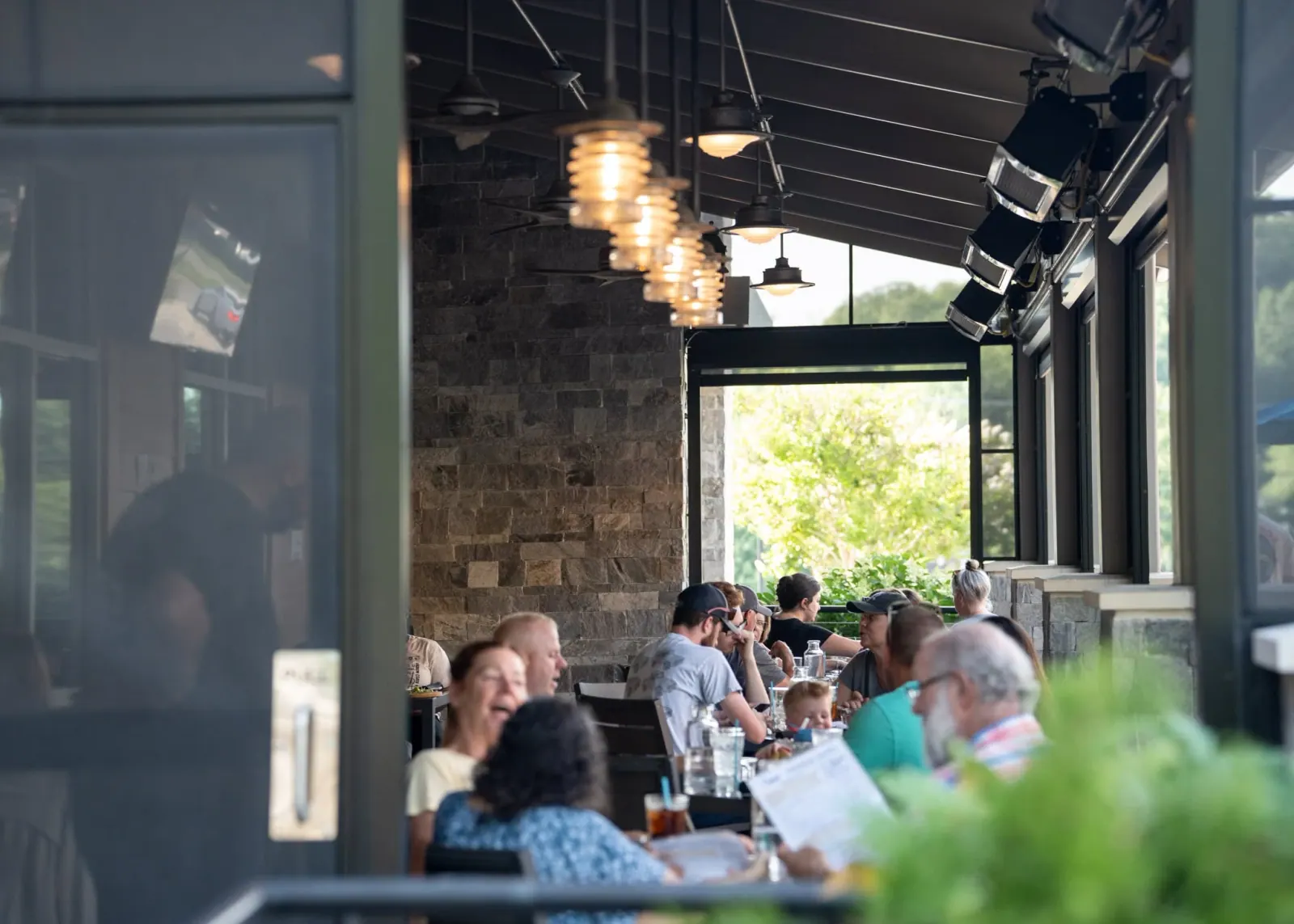 A long view of the covered Charred patio filled with diners