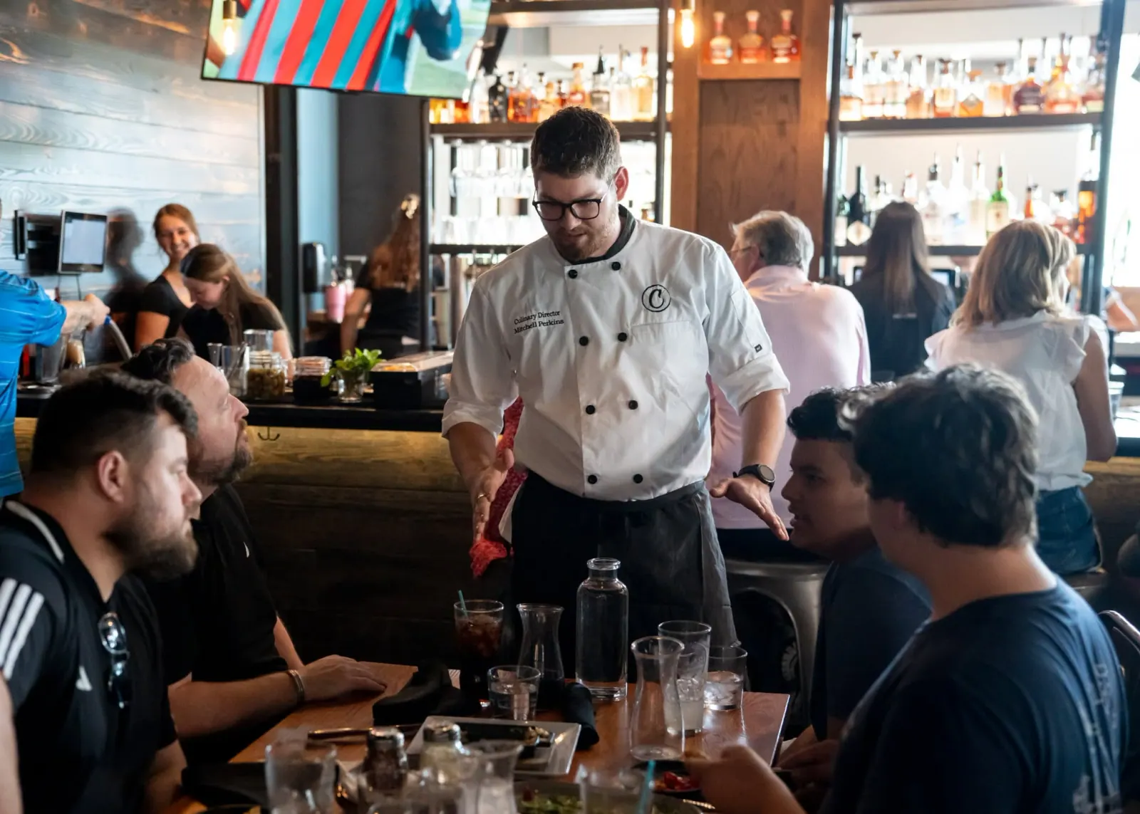 Charred Culinary Director Michael Perkins talking with guests in the dining room