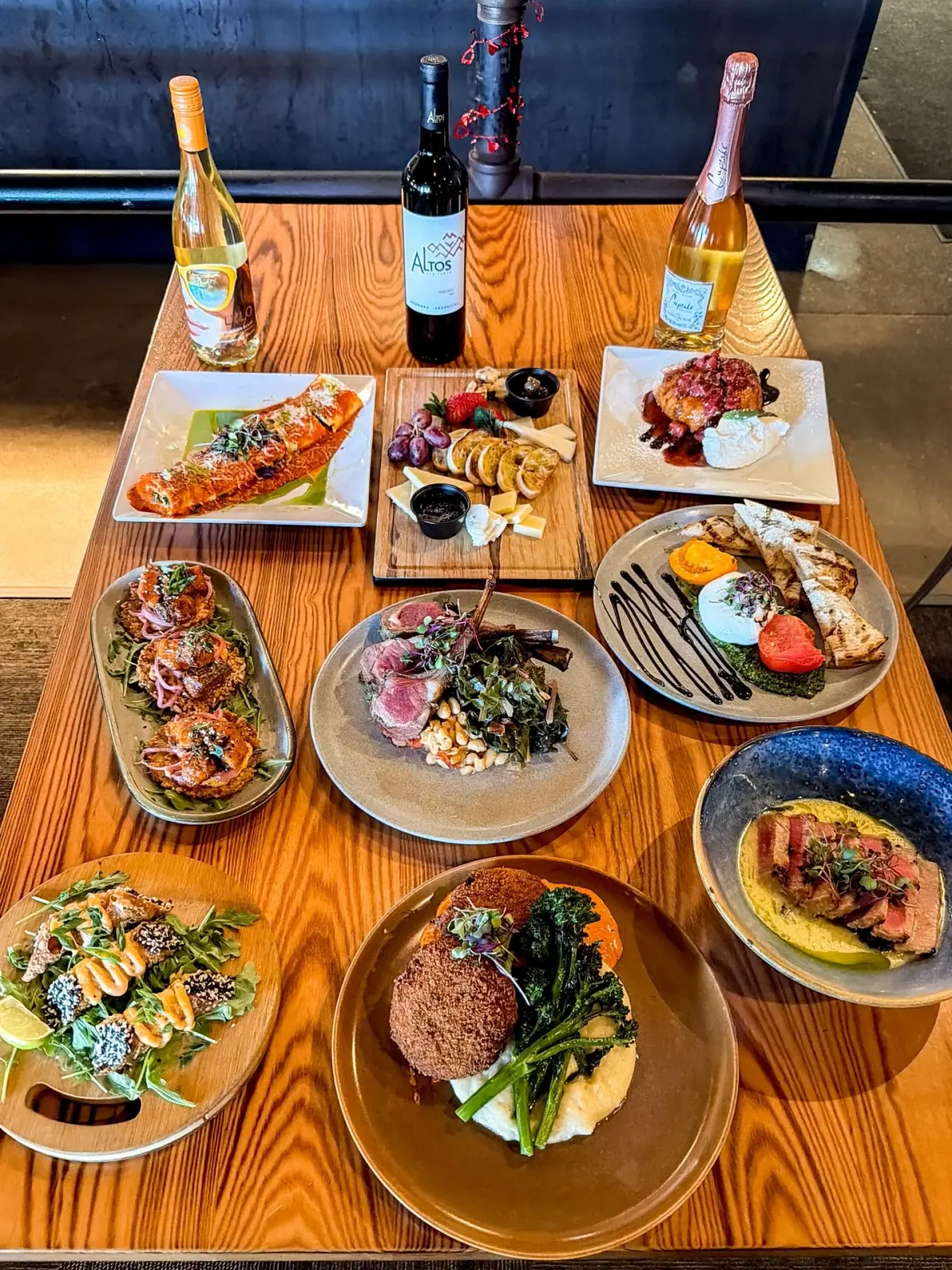 A full Charred table spread with steaks, salads, appetizers, and wine seen from above